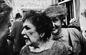 Hedda Hopper eavesdropping on Louella Parsons.