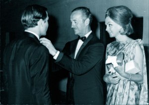 Hjordis looks on as David Niven fixes son Jamie's tie at the premiere of 'The Pink Panther', with JAmie