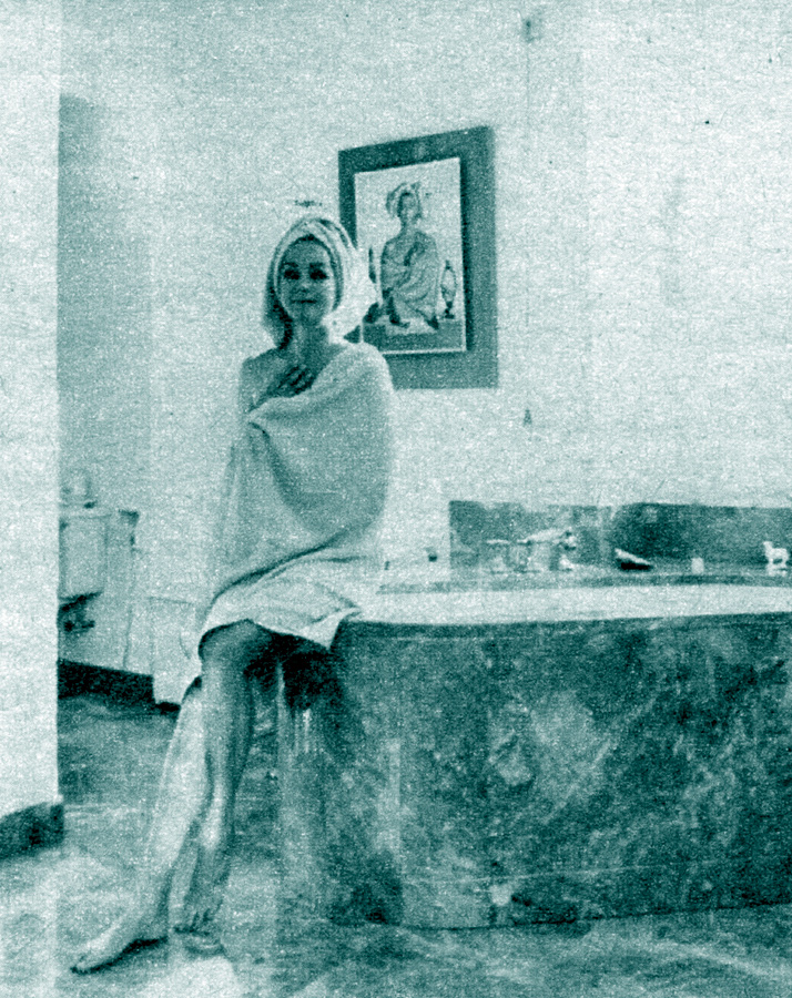 "Hjördis Niven on the edge of the brown marble bathtub. There there are large built-in cabinets with space for underwear, trousers and jumpers so that she can get fully dressed after a bath without having to go leave the bathroom."
